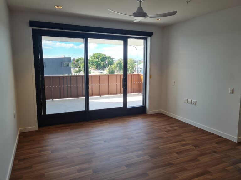 Youngcare-EastBrisbane, bedroom with large glass door opening to balcony. 