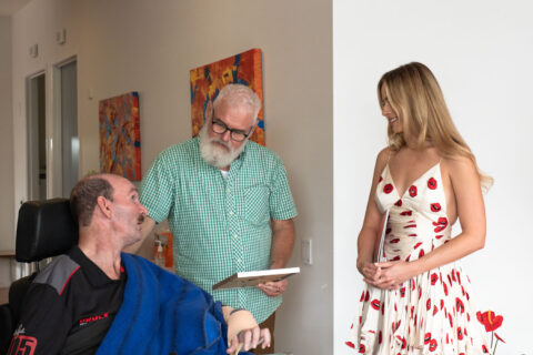 Margot Robbie, Youngcare resident, Carl, and a carer are talking inside a Youngcare share house.